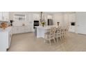 Bright kitchen boasts a large island with seating, white cabinetry, and stainless steel appliances at 19334 Banfield Pl, Orlando, FL 32827
