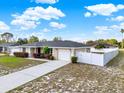 Charming single-story home with a well-manicured front yard, long driveway, and a white picket fence at 2764 W Covington Dr, Deltona, FL 32738