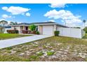 Charming single-story home with a well-manicured front yard, long driveway, and a white picket fence at 2764 W Covington Dr, Deltona, FL 32738