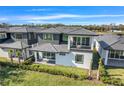 Home featuring a well-manicured lawn, a small patio, and an upstairs balcony in a contemporary style at 3024 Kensington Ave, Davenport, FL 33837