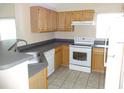 Functional kitchen with wood cabinetry, a new range, and a stainless steel sink under natural light at 3364 Westchester Square Blvd # 204, Orlando, FL 32835