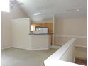 Bright living room features vaulted ceilings, a ceiling fan, and a breakfast bar leading into the kitchen at 3364 Westchester Square Blvd # 204, Orlando, FL 32835