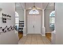 Bright foyer featuring tile flooring, a modern chandelier, and white columns, offering a grand entrance at 3436 Herringridge Dr, Orlando, FL 32812