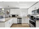 Bright kitchen featuring white cabinetry, stainless steel appliances, and stone countertops at 5163 Lighthouse Rd, Orlando, FL 32808