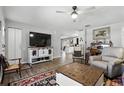A cozy living room with wood floors and neutral walls is staged with chairs, TV and rugs at 5163 Lighthouse Rd, Orlando, FL 32808