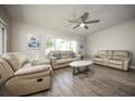 Cozy living room featuring hardwood floors, neutral walls, a ceiling fan, and lots of natural light at 605 Oranole Rd, Maitland, FL 32751