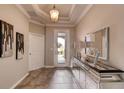 Elegant entryway featuring tile flooring, a mirrored console table, and a view of the landscaped front yard at 796 Mocking Jay Ln, St Cloud, FL 34771