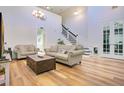 Spacious living room featuring soaring ceilings and a staircase, complete with two comfortable sofas and a wooden coffee table at 8555 Abbotsbury Dr, Windermere, FL 34786