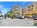 Street view of yellow condo building with breezeway, sidewalk and landscaping at 860 N Orange Ave # 226, Orlando, FL 32801
