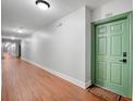 Hallway with wood floors leading to unit 226 with green door and welcome mat at 860 N Orange Ave # 226, Orlando, FL 32801