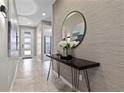 Welcoming entryway with modern console table, round mirror, and stylish decor, leading to a bright interior at 8953 Amelia Downs Trl, Kissimmee, FL 34747