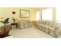 Bright living room with floral patterned sofas, tile floors, and large windows providing natural light at 9311 Sonia St, Orlando, FL 32825