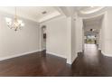 Elegant dining room with dark hardwood floors, chandelier, and tray ceiling at 970 Timberview Rd, Clermont, FL 34715