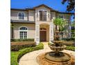 Elegant two-story home featuring a beautifully landscaped front garden and fountain at 9907 Beaufort Ct, Windermere, FL 34786