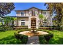 Charming two-story home with a beautiful front garden and water fountain feature at 9907 Beaufort Ct, Windermere, FL 34786