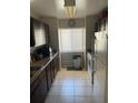 Kitchen view of narrow space with tiled floors, range, and refrigerator at 1001 Spring Meadow # 1001, Kissimmee, FL 34741