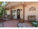 Inviting front porch featuring wicker furniture, decorative plants, and a stylish front door with stained glass at 10423 Manassas Cir, Orlando, FL 32821