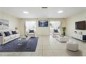 Bright living room with tiled floor, white furniture, area rug, and french doors that lead to a balcony at 10423 Manassas Cir, Orlando, FL 32821