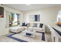 Bright living room with an L-shaped couch, plush rug, and a modern coffee table at 10423 Manassas Cir, Orlando, FL 32821