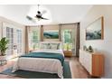 Comfortable main bedroom with fan, wood floors, and large windows providing natural light at 10423 Manassas Cir, Orlando, FL 32821