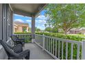 Inviting porch with seating area and view of the well-manicured front yard and neighborhood at 10435 Eastpark Lake Dr, Orlando, FL 32832