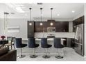 Bright kitchen featuring dark cabinets, stainless steel appliances, and a center island with bar seating at 1109 Castlevecchio Loop, Orlando, FL 32825
