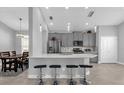 Open-concept kitchen with stainless steel appliances, quartz countertops, and bar seating at 1210 Pando Loop, Orlando, FL 32824