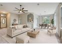 Open-concept living room with modern furnishings, ceiling fan, and ample natural light with dining room in background at 13245 Shore Dr, Winter Garden, FL 34787
