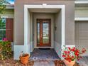 Inviting front entrance with a decorative glass door, brick pavers, and colorful potted plants at 14001 Jomatt Loop, Winter Garden, FL 34787