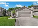 Charming home featuring a two-car garage, well-kept lawn, and decorative shrubbery at 145 Circle Hill Rd, Sanford, FL 32773