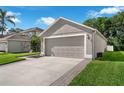 Spacious two-car garage with manicured lawn, and adjacent landscaping at 145 Circle Hill Rd, Sanford, FL 32773