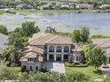 Sprawling lakefront home with a tile roof, lush landscaping, and private dock at 14700 Avenue Of The Rushes, Winter Garden, FL 34787