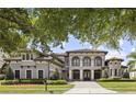 Beautiful home with mature landscaping, arched features, and a tile roof, situated on a well-maintained lawn at 14700 Avenue Of The Rushes, Winter Garden, FL 34787