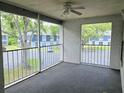 Screened porch featuring neutral carpet, ceiling fan, and views of the parking area and neighboring buildings at 1607 Northlake Dr # 1607, Sanford, FL 32773