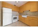 Functional kitchen featuring bright yellow cabinetry, white appliances, and stylish tiled backsplash at 1821 Goodrich Ave, Winter Park, FL 32789