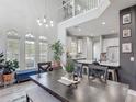 Open dining room featuring high ceilings, large windows, and modern decor with an adjacent kitchen at 2012 Gold Spring Cv, Kissimmee, FL 34743