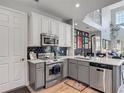 Updated kitchen featuring stainless steel appliances, white cabinets, a gray island, and sleek backsplash at 2012 Gold Spring Cv, Kissimmee, FL 34743