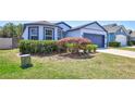 Charming single Gathering home featuring a two-car garage, well manicured lawn, and unique blue trim at 2308 Glenbrook Chase Blvd, Lakeland, FL 33811