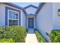 Inviting front entrance with a well-maintained walkway and lush landscaping, leading to a modern, blue front door at 2308 Glenbrook Chase Blvd, Lakeland, FL 33811