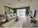 Bright and airy living room with views of the lake, featuring a comfortable sofa and modern decor at 2741 Nottel Dr, St Cloud, FL 34772