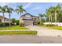 Two story home featuring mature landscaping, palm trees and a two car garage at 305 Kays Landing Dr, Sanford, FL 32771
