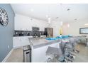 Modern kitchen with stainless steel appliances, a large island with seating, and pendant lighting at 4188 Paragraph Dr, Kissimmee, FL 34746