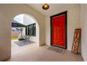 Inviting arched porch entrance with a striking red door and outdoor seating area at 420 N Center St, Eustis, FL 32726