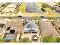 An aerial view of a home with solar panels, a patio, and a manicured lawn at 460 Crownclover Ave, Orlando, FL 32828