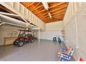 Well-lit and spacious garage with a golf cart, bicycle, and ample storage space, perfect for hobbyists at 505 S Cooper St, New Smyrna Beach, FL 32169