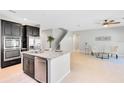Open kitchen featuring an island with granite countertop and stainless steel appliances, connected to a living area at 540 Seven Oaks Blvd, Winter Springs, FL 32708