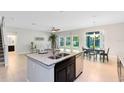 Kitchen island view shows stainless appliances, a dining area, and a staircase at 540 Seven Oaks Blvd, Winter Springs, FL 32708