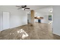 Open-concept living room with ceramic tile flooring, a stone column, and a ceiling fan at 5939 Stokes Rd, Lakeland, FL 33812