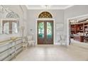 Elegant foyer with tile flooring, decorative mirror and console, chandelier, and view to office at 9018 Southern Breeze Dr, Orlando, FL 32836