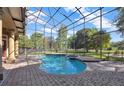 Screened-in pool and spa featuring brick surround, patio, and view of the backyard at 9018 Southern Breeze Dr, Orlando, FL 32836